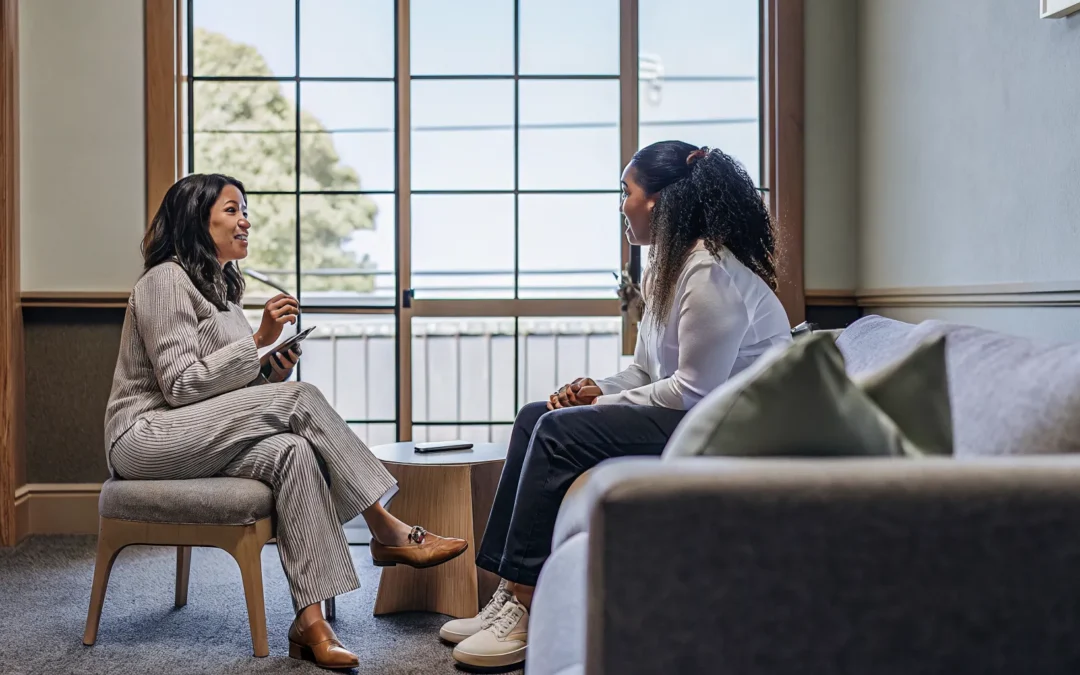 Therapist speaking with a patient in a warm, modern outpatient counseling office in Sarasota